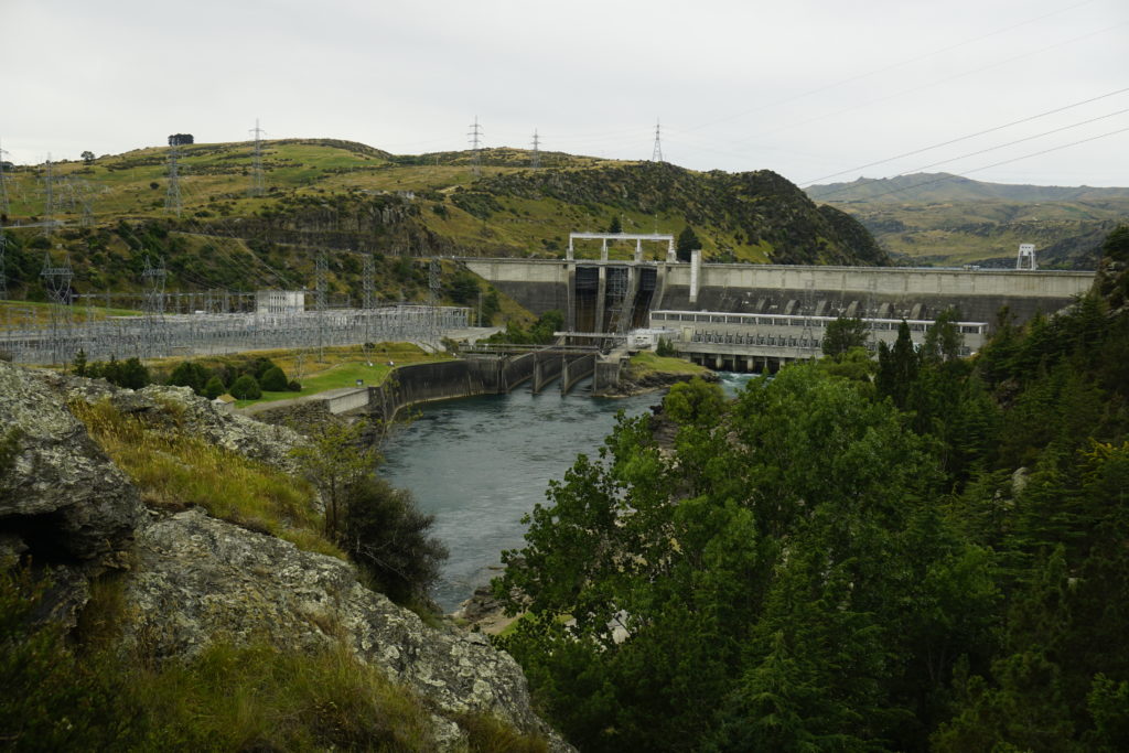 Hydraulic power plant in Roxburgh, New Zealand, with the dam wall in background and the Clutha river in foreground after passing the turbines on a covered ay