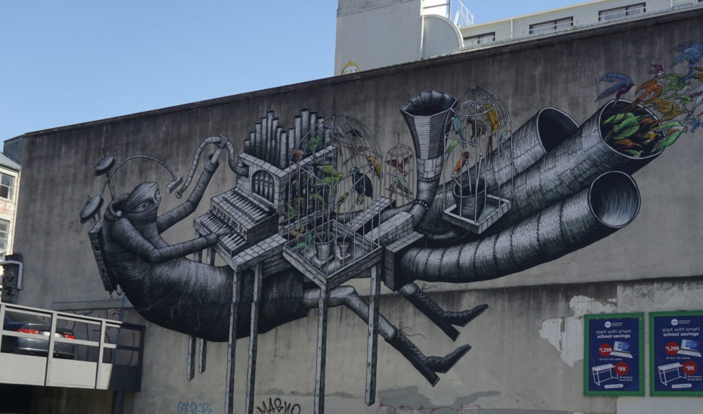 Street Art Dunedin, a drawing on a wall, a IT like person plays a futuristic instrument